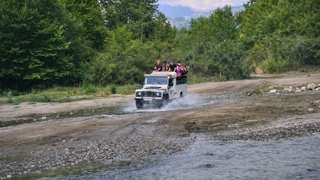 Antalya jeep safari crossing river with water splash and Taurus Mountains in background