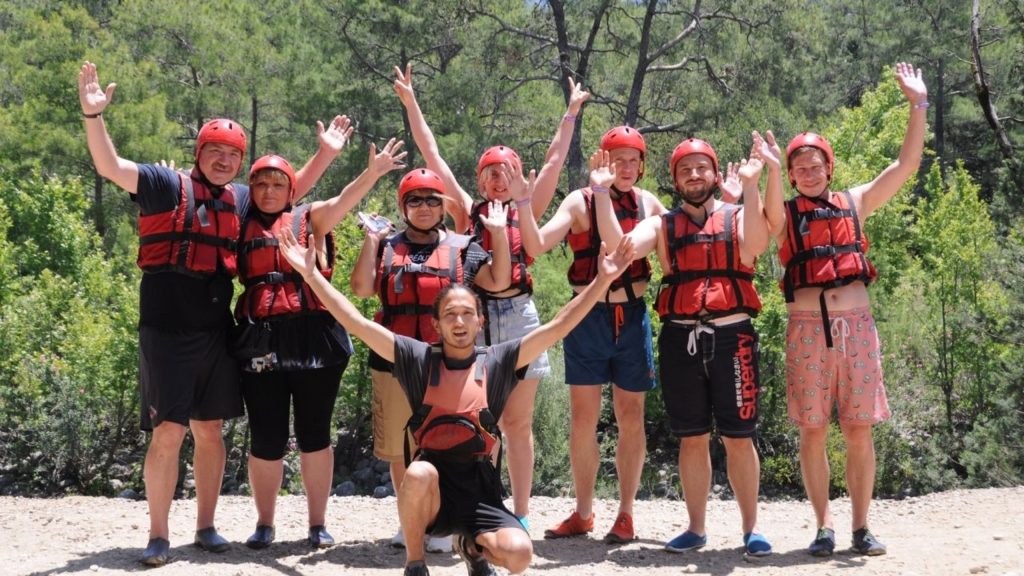 Happy group with helmets and life jackets after Antalya Rafting and Zipline Tour