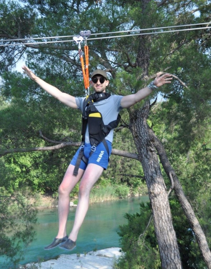 Man with arms spread on zipline above turquoise river during Antalya adventure tour