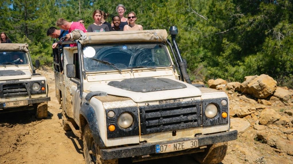 Tourists enjoying a jeep safari ride on muddy forest roads during Antalya adventure combo tour